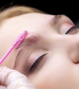 eyebrow lamination procedure the master applies gel with a brush to the eyebrows of the model